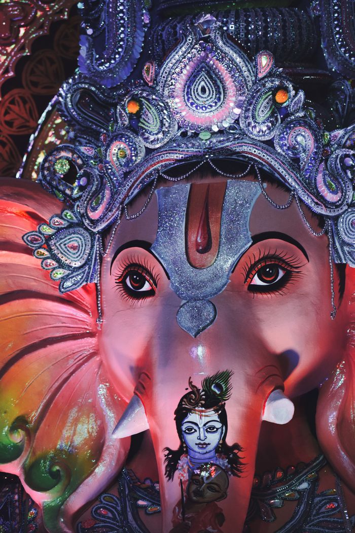 Colorful and ornate Ganesha statue decorated in a traditional style, captured in a temple setting.