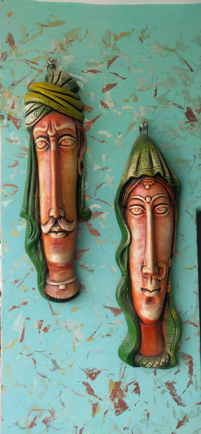 Colorful Indian sculptures on a textured wall showcasing traditional art forms.